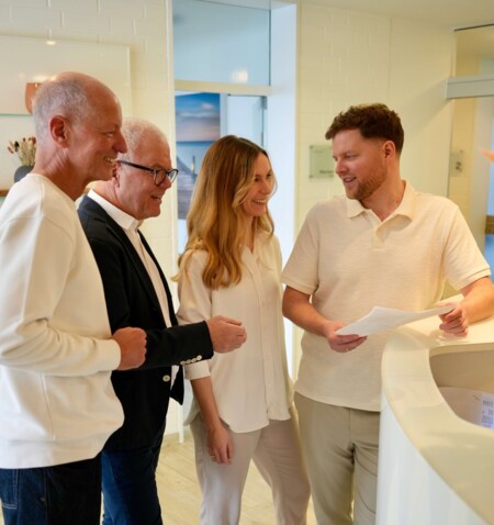 Die Behandlerinnen und Behandler unterhalten sich an der Rezeption. Von links nach rechts: Sven Fehring, Wolfgang Jordan, Isabell Jordan, Erik Jordan.