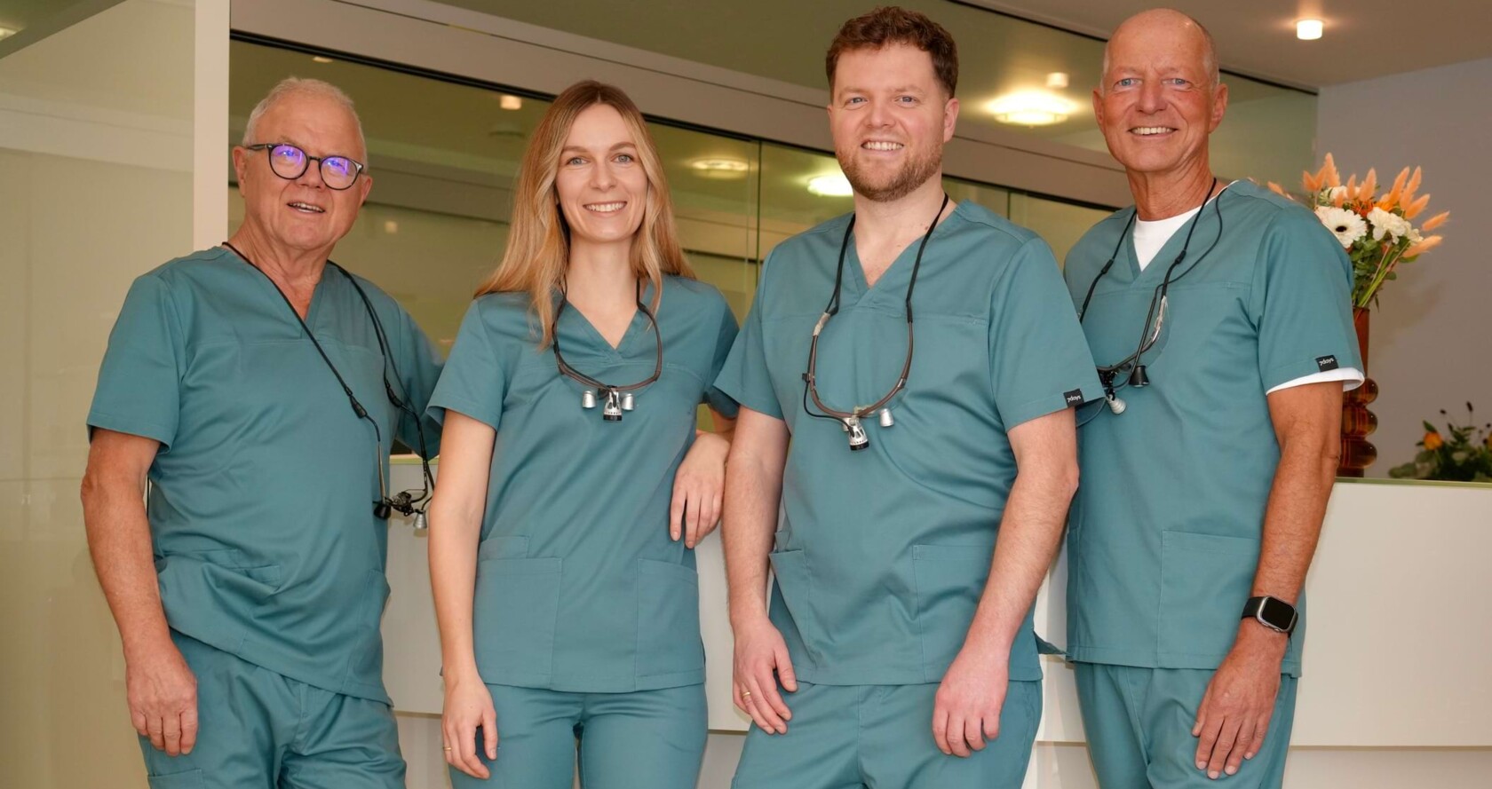 Portr&auml;tbild der Behandlerinnen und Behandler vor der Rezeption. Von links nach rechts: Wolfgang Jordan, Isabell Jordan, Erik Jordan, Sven Fehring.